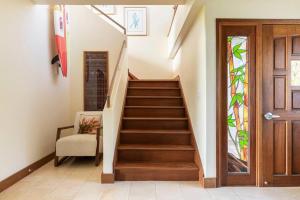 Una escalera en una casa con puerta de madera en Maluhia ~ Peace & Tranquility, en Haleiwa