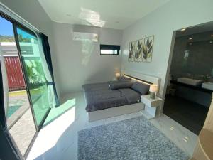 une chambre avec un lit et une grande fenêtre dans l'établissement Costa Lota villa, brand new, 3 bedroom, in rawai V35, à Ban Saiyuan (1) 33 autres photos