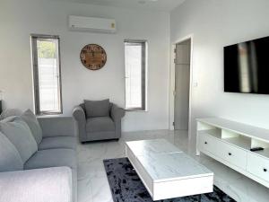 un salon avec un canapé et une télévision dans l'établissement Costa Lota villa, brand new, 3 bedroom, in rawai V35, à Ban Saiyuan (1)