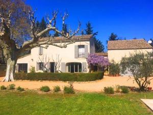 una gran casa blanca con un árbol delante en Provencal farmhouse, pool, pool house, countryside Plan d’Orgon, Provence - 8 people, en Cavaillon