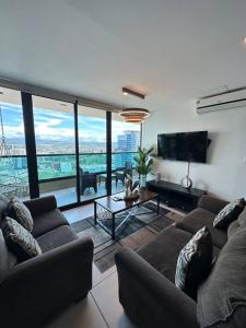 een woonkamer met 2 banken en een groot raam bij Luxury 2BR Apartment in Astria 605 in Tegucigalpa