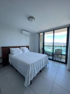 1 dormitorio con cama blanca y ventana grande en Luxury 2BR Apartment in Astria 605 en Tegucigalpa