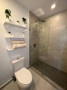 y baño con aseo y ducha acristalada. en Luxury 2BR Apartment in Astria 605 en Tegucigalpa