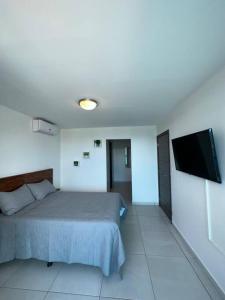 1 dormitorio con 1 cama y TV de pantalla plana en Luxury 2BR Apartment in Astria 605 en Tegucigalpa
