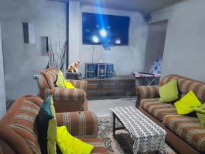 sala de estar con 2 sofás y TV en ENCALADA en Otavalo