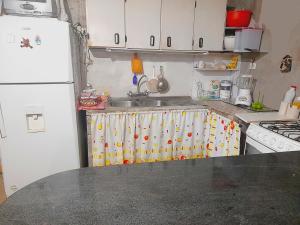 La cuisine est équipée d'un évier et d'un réfrigérateur blanc. dans l'établissement ENCALADA, à Otavalo