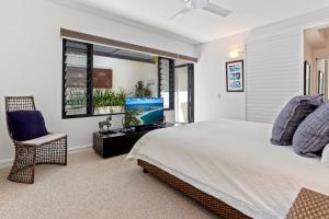 a bedroom with a bed and a tv and a chair at Laidback luxury living, Noosa Heads in Noosa Heads +9 photos