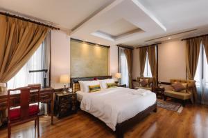 - une chambre avec un lit, un bureau et une chaise dans l'établissement Lunar Mansion Hotel, à Chiang Mai