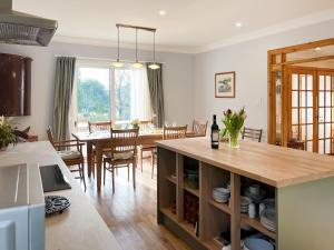 a kitchen and living room with a table and a dining room at The Byre in Tayvallich