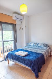 1 dormitorio con 1 cama con manta azul y ventana en Misionerita en Posadas