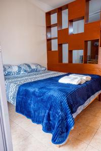Un dormitorio con una cama con una manta azul. en Misionerita en Posadas