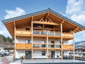 a timber building with a large balcony at Thunhaus Apartments with ski-storage in Uderns