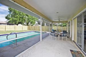 eine Terrasse mit einem Pool, einem Tisch und Stühlen in der Unterkunft Classic Floridian Oasis w/Pool in North Port