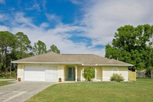 a small yellow house with a garage at Classic Floridian Oasis w/Pool in North Port
