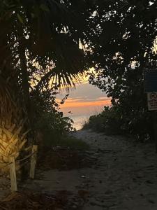 eine unbefestigte Straße, die zu einem Strand mit Sonnenuntergang führt in der Unterkunft Classic Floridian Oasis w/Pool in North Port