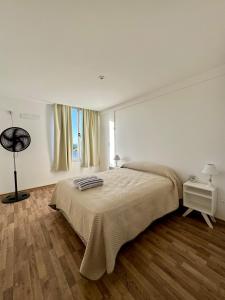 een witte slaapkamer met een bed en een raam bij DEPTO38 in La Plata