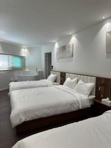 Un dormitorio con dos camas con sábanas blancas. en Moderno, en Seúl