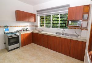 una cucina con armadi in legno, lavandino e finestra di PARADISE LODGE a Tena