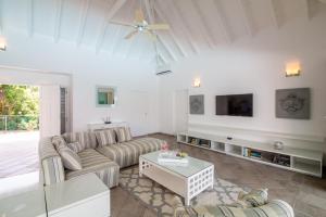 een woonkamer met een bank en een tv bij Luxury Vacation Villa 7 in Les Terres Basses