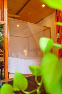 a bedroom with a white bed with a canopy at Agonda Serenity Resort in Agonda