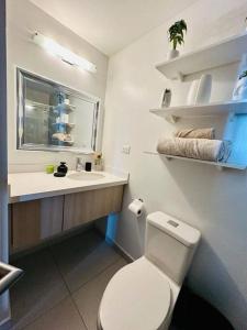a bathroom with a white toilet and a sink at Luxury 1BR Apartment in Astria 706 in Tegucigalpa