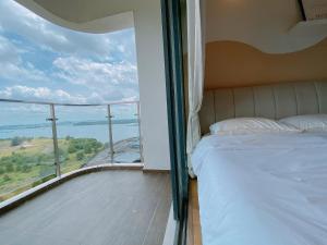 sypialnia z łóżkiem i balkonem z widokiem w obiekcie Country Garden Danga Bay by Lions Bay w mieście Johor Bahru