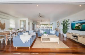a living room with blue couches and a dining room at A Point of View in Airlie Beach