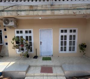 Habitación con puerta blanca y 2 ventanas en Omah Sidoarum Homestay Jogja, en Godean