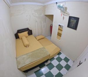 a bedroom with a bed in a small room at Omah Sidoarum Homestay Jogja in Godean