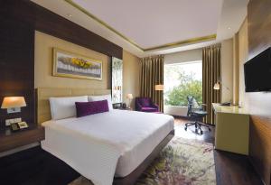 a bedroom with a large white bed and a desk at DoubleTree by Hilton Gurugram Baani Square in Gurgaon