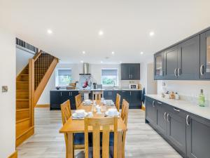 cocina con mesa de comedor y cocina con armarios azules en Home Farm Cottage, en Sawley
