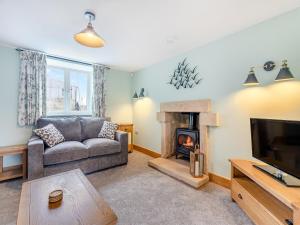 a living room with a couch and a fireplace at Home Farm Cottage in Sawley