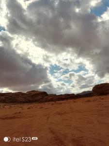 a cloudy sky in the desert with a dirt field at Desert Life Camp in Wadi Rum