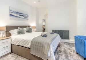 卡地夫的住宿－Hafan y Ddinas Cardiff Apartment 2，一间卧室配有一张大床和一张蓝色椅子