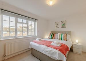 a bedroom with a bed and a large window at By The Bay in Westgate-on-Sea