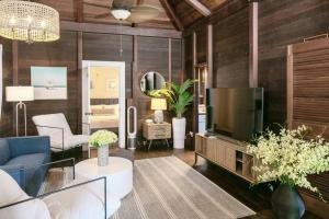 a living room with wood paneling and a large television at Stunning Cottage with Ocean Views Near Beaches in Enighed
