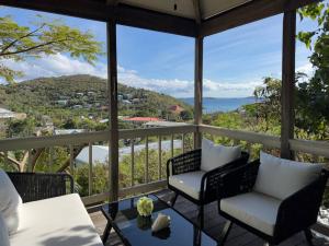 a screened in porch with two chairs and a table at Stunning Cottage with Ocean Views Near Beaches in Enighed