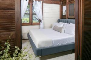 Cama azul en habitación con ventana en Stunning Cottage with Ocean Views Near Beaches, en Enighed