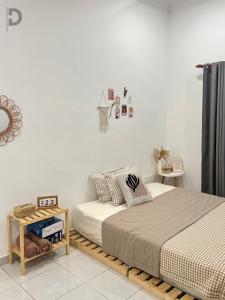 a bedroom with a bed and a side table at DE WHITE HOMESTAY . PORT DICKSON in Port Dickson