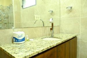 encimera con lavabo y espejo en Villas Del Ángel - El Naranjal, en La Ceiba