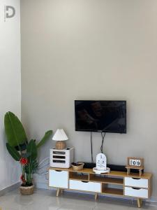 a living room with a tv on a white wall at DE WHITE HOMESTAY . PORT DICKSON in Port Dickson