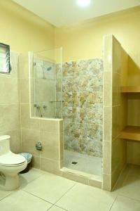 ein Bad mit einer Dusche und einem WC in der Unterkunft Villas Del Ángel - El Naranjal in La Ceiba