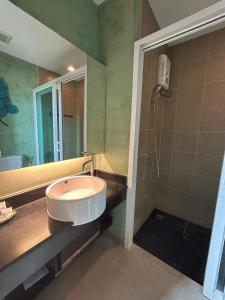 La salle de bains est pourvue d'un lavabo et d'une douche. dans l'établissement โรงแรม ดิ โอวาเล่ย์ [The O Valley Boutique Hotel], 