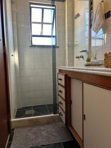 a bathroom with a shower and a sink at Iguaba Grande, 3 minutos do mar in Iguaba Grande