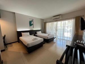 a hotel room with two beds and a window at โรงแรม ดิ โอวาเล่ย์ [The O Valley Boutique Hotel] 