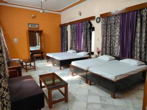 una camera da letto con due letti e un soggiorno di Shantiniketan - Comfortable Stay in Ayodhya a Ayodhya