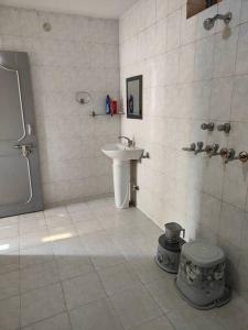 La salle de bains blanche est pourvue d'un lavabo et de toilettes. dans l'établissement Shantiniketan - Comfortable Stay in Ayodhya, à Ayodhya