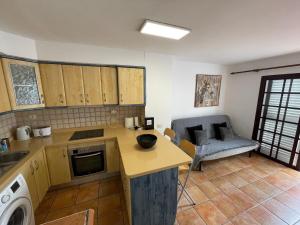 eine Küche mit einem Tisch und einem Sofa in einem Zimmer in der Unterkunft Olivia’s house in Maspalomas
