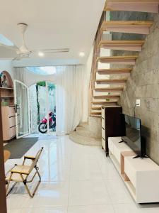 a living room with a tv and a staircase at DORI HOUSE NTL in Ho Chi Minh City