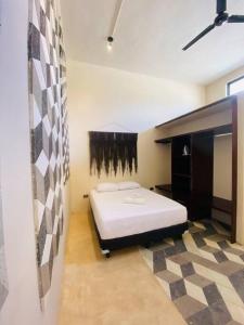 a bedroom with a white bed in a room at Ko'ox 52 in Mérida